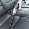 Vacuum being used to clean car seats
