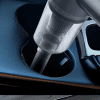 Vacuum being used to clean car cup holder