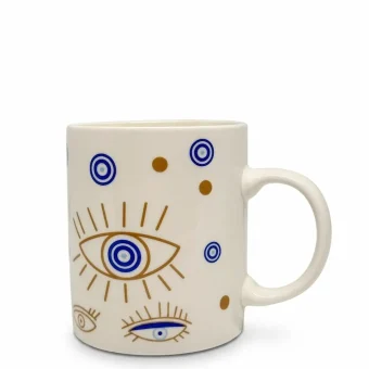 A white ceramic mug featuring a gold and blue evil eye pattern, displayed on a clean white background