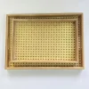A top-down view of a set of two natural rattan and bamboo serving trays nested inside each other,