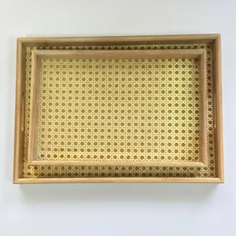 A top-down view of a set of two natural rattan and bamboo serving trays nested inside each other,