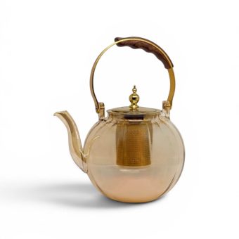 A side view of an elegant honey glass teapot featuring a gold infuser and a wooden handle