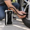 Man inflating a car tire with the Nexera portable air compressor